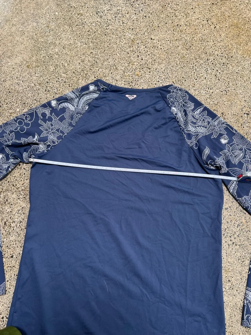 Roxy rashguard in blue with white floral design at sleeves